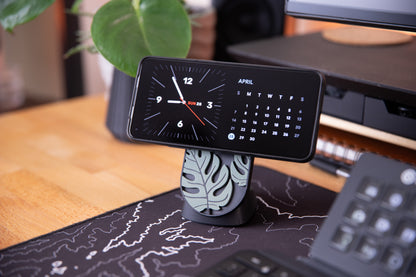 monsterra magsafe charger 3d print with phone mounted sitting on desk mat with plants in the background.